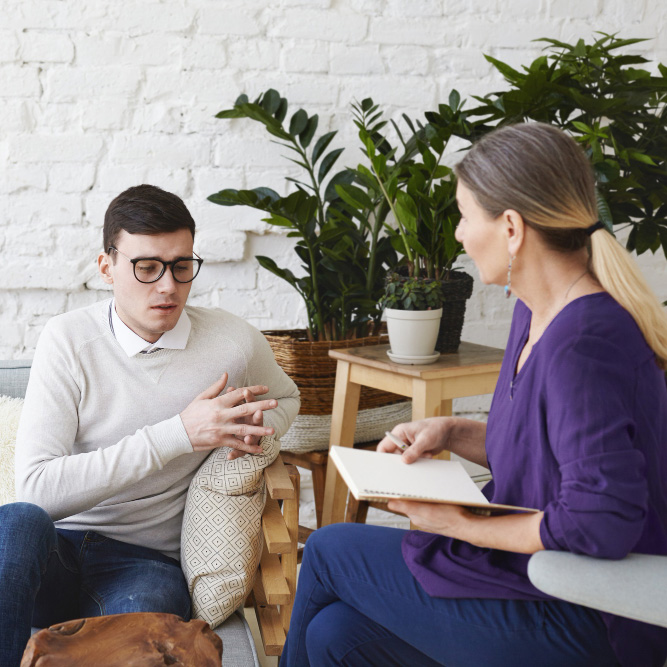 Therapy session with female therapist and male client.