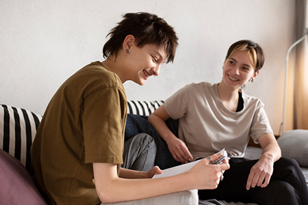 LGBTQIA+ couple sitting on couch and talking.