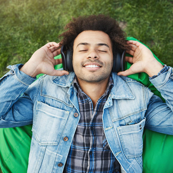 Man relaxing and listening to Safe and Sound Protocol on headphones