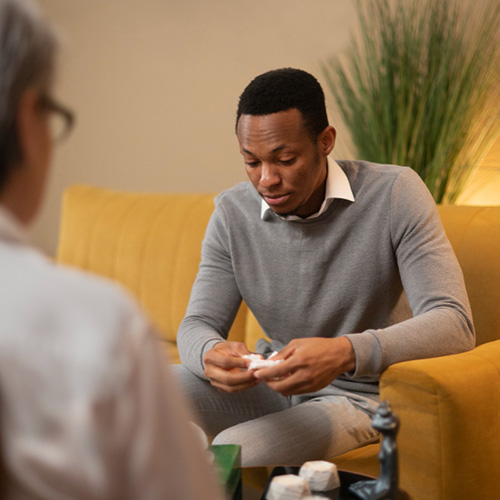 Black man in therapy talking about emotions.