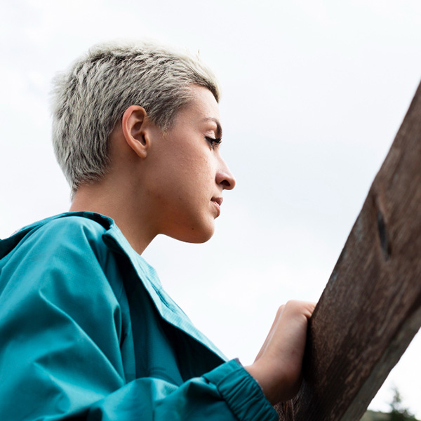 Woman with blond hair looking off into the distance looking pensive.